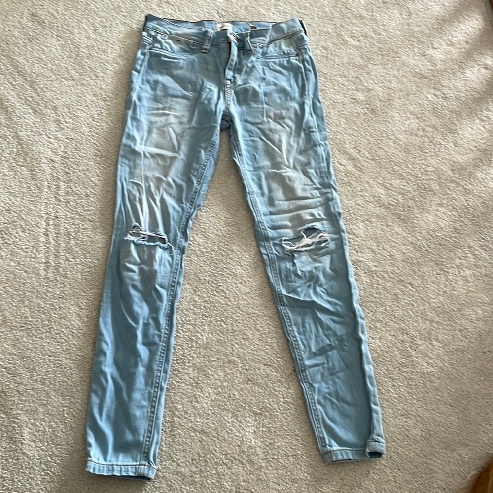 Light wash mid-rise jeans with rips in the knees